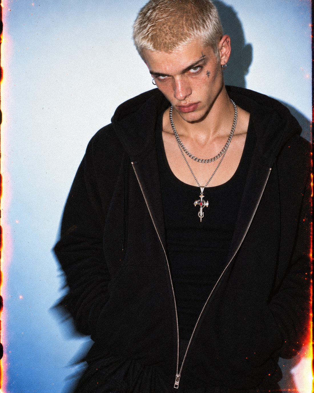 AI-assisted styling illustration of layered silver-tone necklaces inside an open black zip hoodie